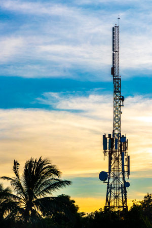 Red white 5G tower with blue sky background radiation kills us with sunset palm tree sky background in Zicatela Puerto Escondido Oaxaca Mexico.の写真素材