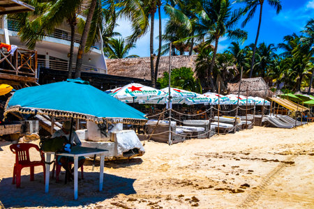 Tropical mexican caribbean beach and sea with people sun loungers parasols resort turquoise water and waves in Playa del Carmen Quintana Roo Mexico.のeditorial素材