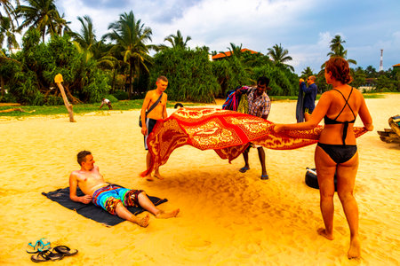 Beautiful beach with tropical nature sand water waves people fun parasols and sun loungers in Bentota Beach on Sri Lanka island.のeditorial素材