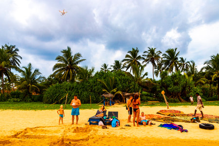 Beautiful beach with tropical nature sand water waves people fun parasols and sun loungers in Bentota Beach on Sri Lanka island.のeditorial素材