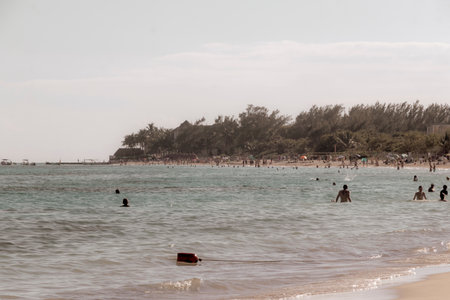 Tropical Mexican Caribbean beach and sea with a lot of fun people sun loungers parasols turquoise...