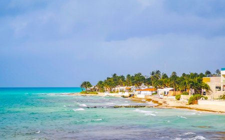 Playa del Carmen Quintana Roo Mexico July 8, 2024 Tropical Caribbean beach and sea with cityscape sun loungers parasols turquoise water hotels city in Playa del Carmen Mexico.の写真素材