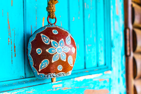 Hanging cowbell on the turquoise blue door.の写真素材