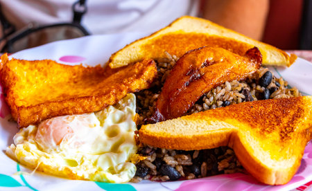 Typical Costa Rican food dish Rice Banana Scrambled eggs Beans and bread in Para Heredia Costa Rica in Central America.の写真素材