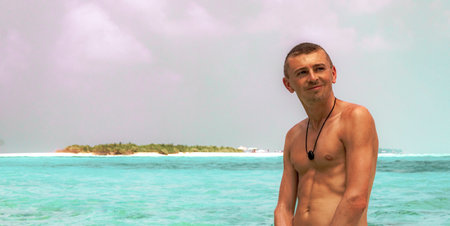 Male young tourist traveler man enjoys vacation in color gradient water at the sandbank islands Madivaru and Finolhu in Rasdhoo Atoll Maldives.の写真素材