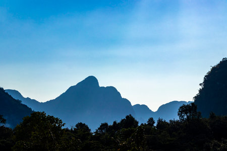 Mountain peak landscape with tropical forest jungle hills rocks and blue sky in Vang Vieng Vientiane...
