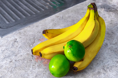 Ripe juicy yellow bananas and lime limes fruit fruits on the table in Playa del Carmen Quintana Roo Mexico.の写真素材