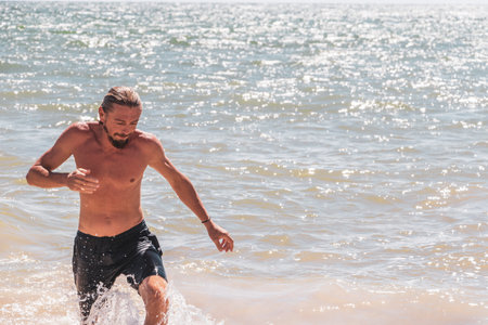Male tourist traveling man with long hair is posing for a photo and having fun swim on the Mexican Caribbean beach in Playa del Carmen Quintana Roo Mexico.の写真素材