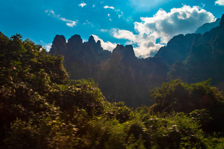 Mountain peak landscape with tropical forest jungle hills rocks and blue sky in Vang Vieng Vientiane Province Laos in Southeastasia Asia.の写真素材