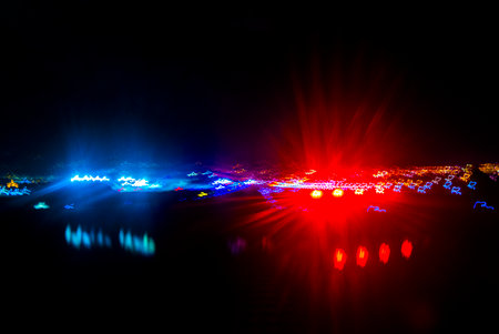 Flight and take off landing airplane over city at night abstract blurred lights colors colorful in Juan Santamaria International Airport in Central America.の写真素材