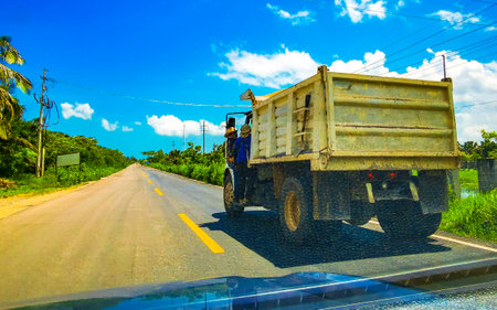 Dump truck and delivery trucks on the highway in the tropical jungle in Chiquila Lazaro Cardenas in Quintana Roo Mexico.の写真素材