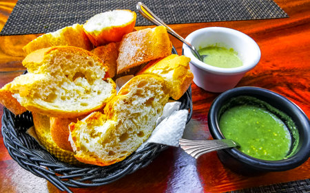 Bread in basket served with green coriander and chili habanero sauce.の写真素材