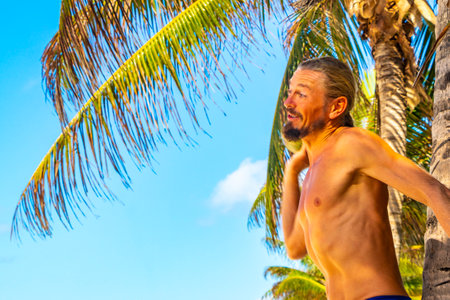 Man throws coconut on beach with palm trees in Playa del Carmen Quintana Roo Mexico.の写真素材