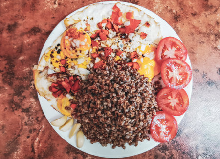 Buckwheat dish on a plate with vegetables tomatoes carrots garlic onions.の写真素材