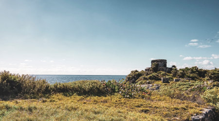Natural seascape and beach panorama view at the ancient Tulum ruins Mayan site with temple of the...