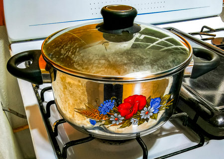 Beautiful cooking pot with floral patterns on stove.の写真素材