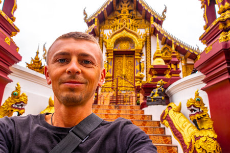 Chiang Mai Amphoe Mueang Chiang Mai Thailand October 31, 2018 Man tourist at golden Wat Rajamontean temple with building house and Buddha sculpture sculptures statue statues in Chiang Mai Thailand.の写真素材
