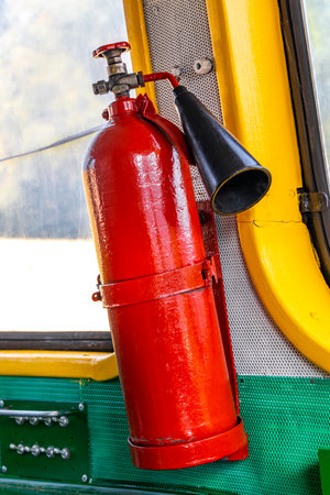 Fire extinguisher inside of a classic vintage old retro train steam locomotive in the Railway...