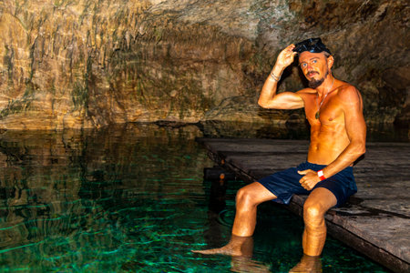 Man male tour guide is swimming and snorkeling in the turquoise green blue water in a cenote Yaxmulito in Tulum Quintana Roo Mexico.の写真素材