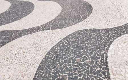 Portuguese pavement calcada black and white style on Copacabana coastal and beach promenade with...