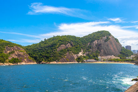 Urca Red Beach Tropical Paradise with Blue Turquoise Water Waves Palm Trees Rocks Hills Cliffs Seascape and White Beach Sand in Rio de Janeiro State of Rio de Janeiro Brazil.の写真素材