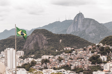 Christ the Redeemer Cristo Redentor statue and Brazilian Flag on Corcovado mountain hill rock and panorama view of Alto da Boa Vista Brazil.の写真素材
