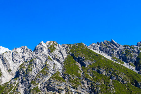 Mountain and alpine hill landscape mountains and rocks peaks panorama with green fields less forest and fir trees rocky nature and blue sky in the Alps Imst Tyrol Austria.の写真素材