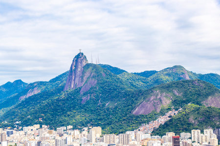 Christ the Redeemer Cristo Redentor on Corcovado mountain hill rock and cityscape city and tropical rainforest blue cloudy sky panorama view of Alto da Boa Vista Brazil.の写真素材