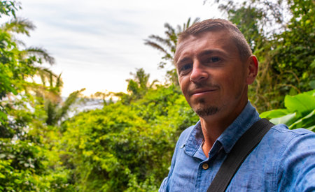 Handsome traveler tourist man on walking path trail hiking in the jungle nature rainforest in the mountains in Rio de Janeiro State of Rio de Janeiro Brazil.の写真素材
