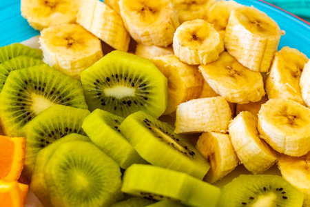 Sliced oranges, kiwi and bananas on a plate in the Alps FlieÃ Landeck Tyrol Austria.の写真素材