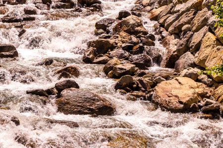 Beautiful flowing river steam and waterfall Inn with stones rocks grass trees nature between mountains in the Alps FlieÃ Landeck Tyrol Austria.の写真素材