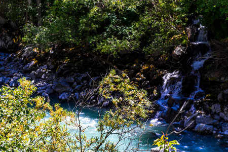 Turquoise blue and green river steam and waterfall Inn with stones rocks grass trees nature between mountains in the Alps FlieÃ Landeck Tyrol Austria.の写真素材