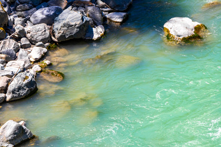 Turquoise blue and green river steam and waterfall Inn with stones rocks grass trees nature between mountains in the Alps FlieÃ Landeck Tyrol Austria.の写真素材