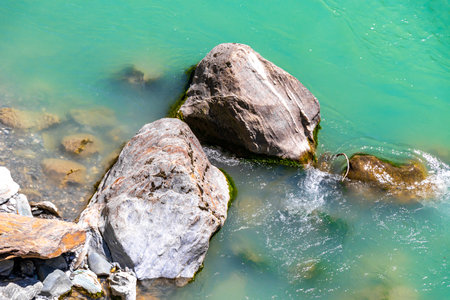 Turquoise blue and green river steam and waterfall Inn with stones rocks grass trees nature between mountains in the Alps FlieÃ Landeck Tyrol Austria.の写真素材