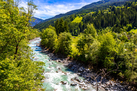 Turquoise blue and green river steam and waterfall Inn with stones rocks grass trees nature and...