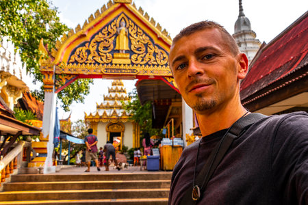 Handsome Man Tourist at the Khao Phra Bat Pattaya Wat Buddhist Temple Entrance Gate and Stairs on Phra Tamnak Mountain Hill in Pattaya Thailand.の写真素材
