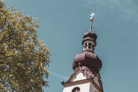 Landeck Tyrol Austria May 30, 2025 Barbara church cathedral Barbarakirche Fliess with dome tower and blue sky in the Alps Fliess Landeck Tyrol Austria.の写真素材