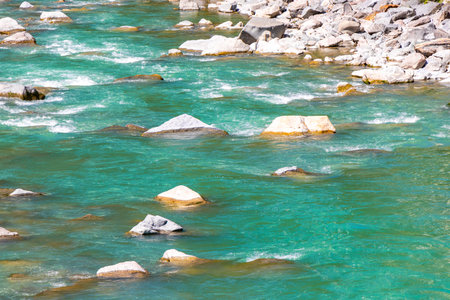 Turquoise blue and green river steam and waterfall Inn with stones rocks grass trees nature between mountains in the Alps in the alps Landeck District Landeck Tyrol Austria.の写真素材