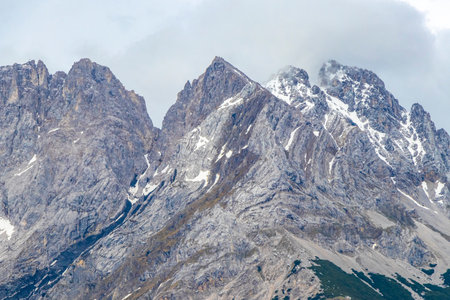 Cold panoramic view of Germanys largest mountain Zugspitze peak alpine landscape with snow rocks hills clouds and mountains in the Alps Biberwier Reutte Tyrol Austria.の写真素材