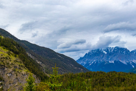 Panorama view of Germanys largest mountain Zugspitze alpine landscape with forest rocks hills snow peak clouds and mountains in the Alps Biberwier Reutte Tyrol Austria.の写真素材