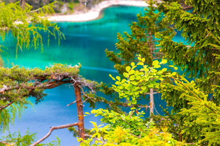 Turquoise blue green Blindsee lake river water forest rocks hills and mountains at Germanys largest mountain Zugspitze alpine landscape panorama in the Alps Biberwier Reutte Tyrol Austria.の写真素材