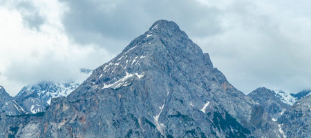 Cold panoramic view of Germanys largest mountain Zugspitze peak alpine landscape with snow rocks hills clouds and mountains in the Alps Biberwier Reutte Tyrol Austria.の写真素材