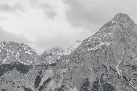 Cold panoramic view of Germanys largest mountain Zugspitze peak alpine landscape with snow rocks hills clouds and mountains in the Alps Biberwier Reutte Tyrol Austria.の写真素材
