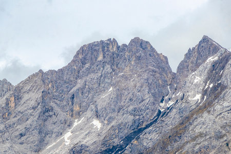 Cold panoramic view of Germanys largest mountain Zugspitze peak alpine landscape with snow rocks hills clouds and mountains in the Alps Biberwier Reutte Tyrol Austria.の写真素材