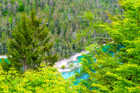 Turquoise blue green Blindsee lake river water forest rocks hills and mountains at Germanys largest mountain Zugspitze alpine landscape panorama in the Alps Biberwier Reutte Tyrol Austria.の写真素材