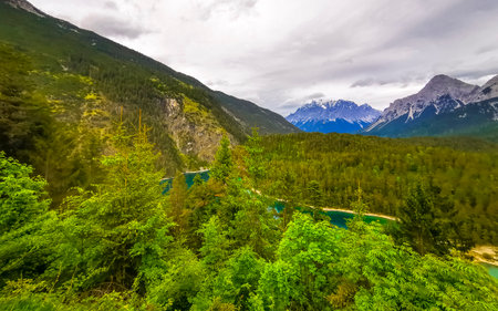 Panoramic view of Germanys largest mountain Zugspitze alpine landscape with turquoise Blindsee lake forest rocks hills and mountains in the Alps Biberwier Reutte Tyrol Austria.の写真素材