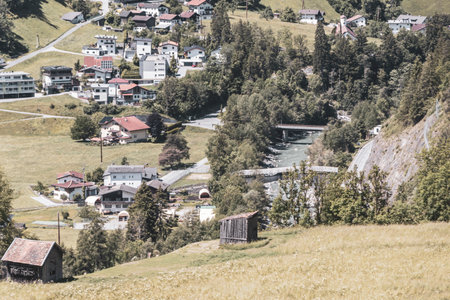 Mountain and alpine hill landscape mountains and peaks panorama view to Nesselgarten village town forest huts houses streets turquoise river Inn and green fields in Austria.の写真素材