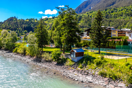 Turquoise blue and green river steam and waterfall Inn with stones rocks grass trees nature between mountains in the Alps in the alps Landeck District Landeck Tyrol Austria.の写真素材