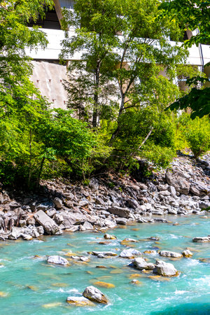 Turquoise blue and green river steam and waterfall Inn with stones rocks grass trees nature between mountains in the Alps in the alps Landeck District Landeck Tyrol Austria.の写真素材