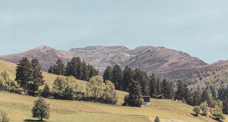 Mountain and alpine hill landscape mountains rocks and peaks panorama with green fields meadows village forest fir trees and cloudy blue sky in Fliess Landeck Tyrol Austria.の写真素材